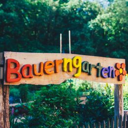 Hinweisschild Bauerngarten in bunten Holzbuchstaben