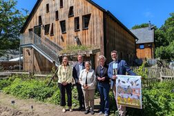 Mehrere Personen stehen mit einem Plakat vor dem Haus der Natur