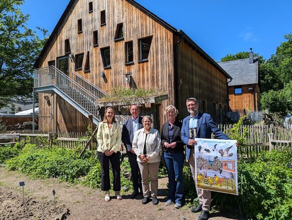 Mehrere Personen stehen mit einem Plakat vor dem Haus der Natur